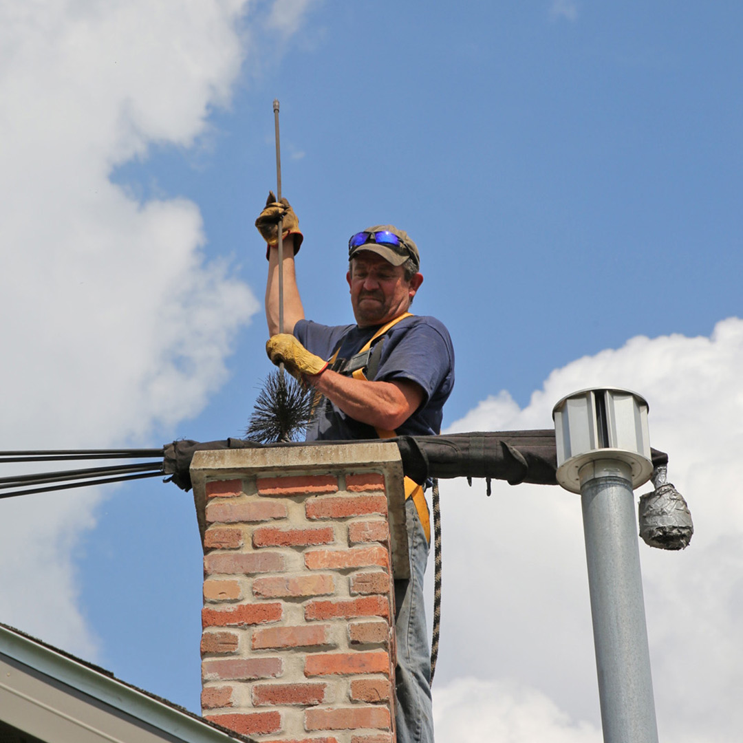 Chimney service team working around an indoor fireplace
